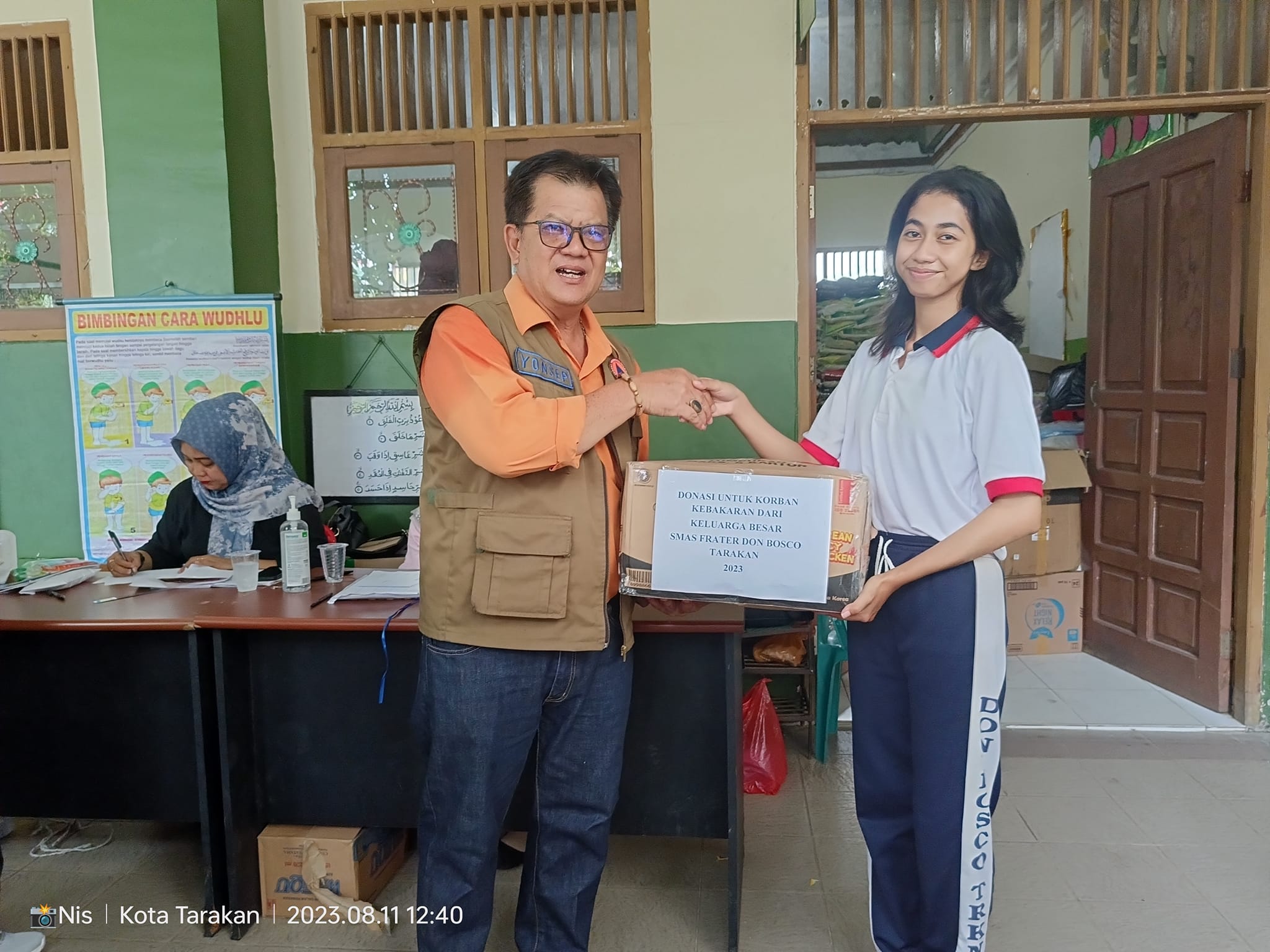 Penyerahan bantuan oleh ketua OSIS, Susan Masandai Werang kepada ketua BNPB kota Tarakan, Bpk Yonsep.